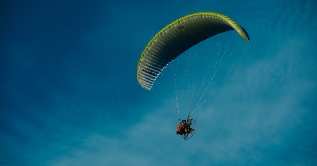 a person is parasailing in the blue sky