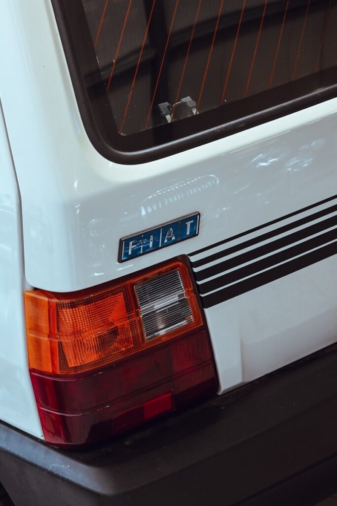 A white fiat car's rear quarter is shown.