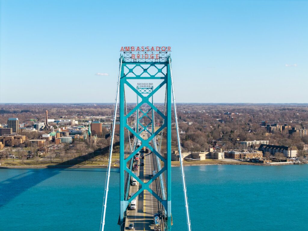 The ambassador bridge spans over the blue river.