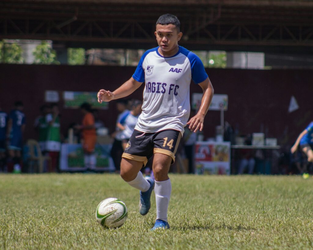a man kicking a soccer ball on a field