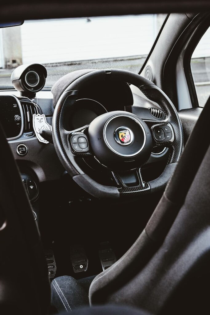 The interior of a car with a steering wheel and dashboard
